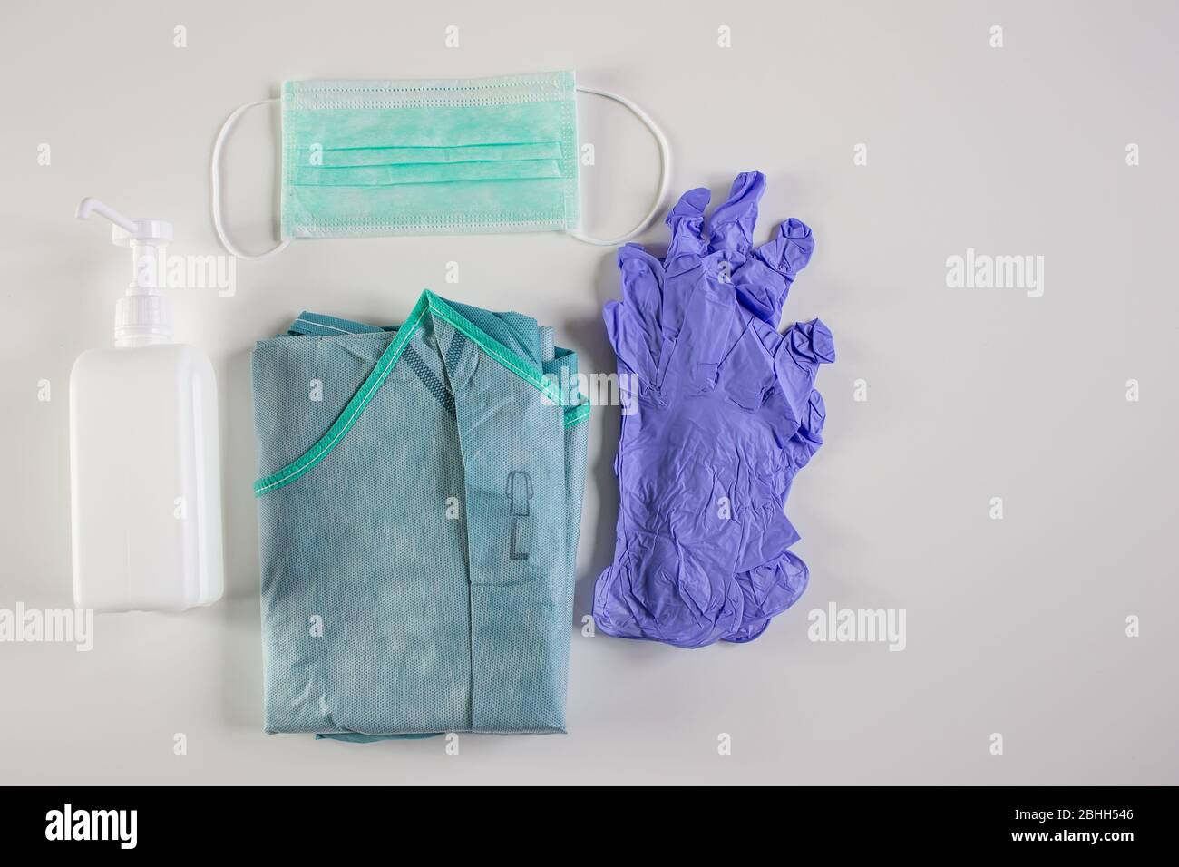 Basic material to protect against the coronavirus, gloves, gown, mask and alcoholic hand cleaner Stock Photo