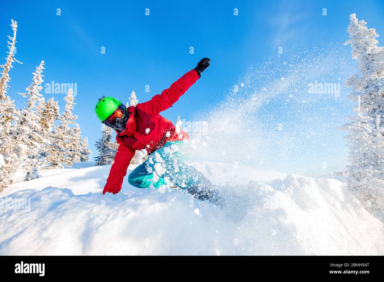 Young man snowboarder running down slope mountains forest. Winter sport ...