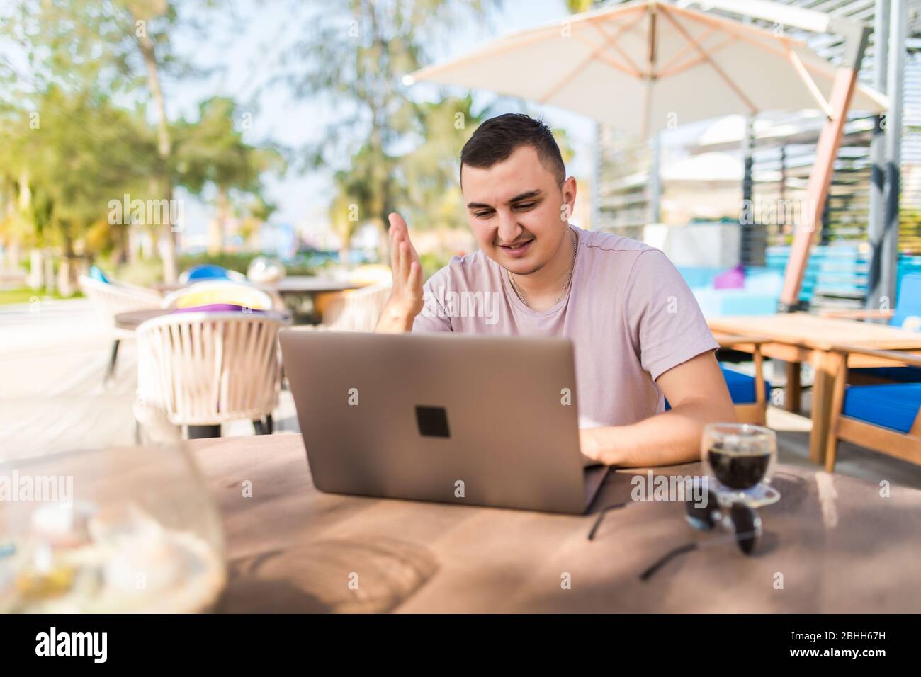 young male work with laptop in cafe outdoors Stock Photo