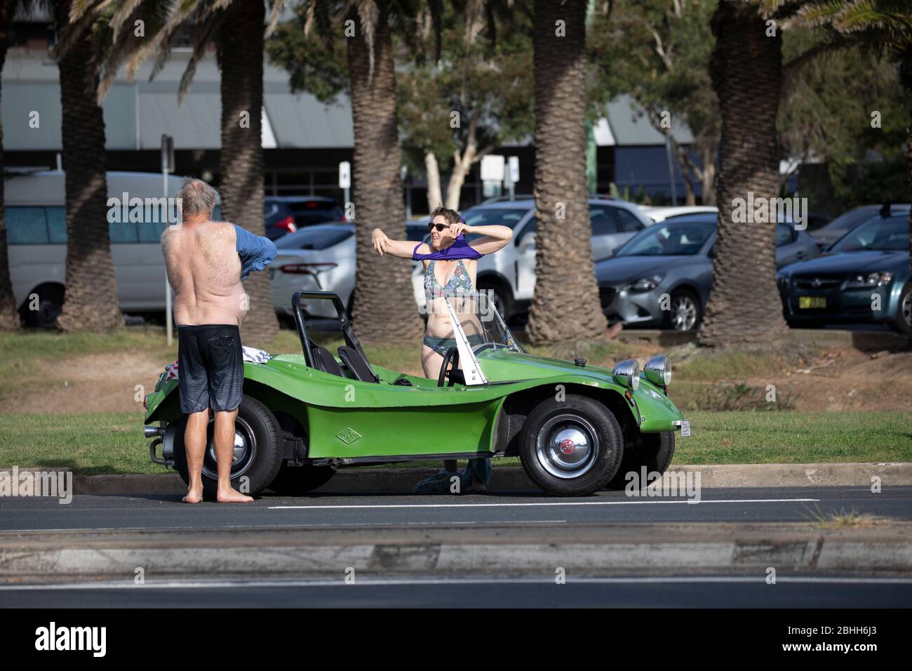 Middle aged couple beside their green beach buggy at Avalon beach in Sydney,Australia Stock Photo