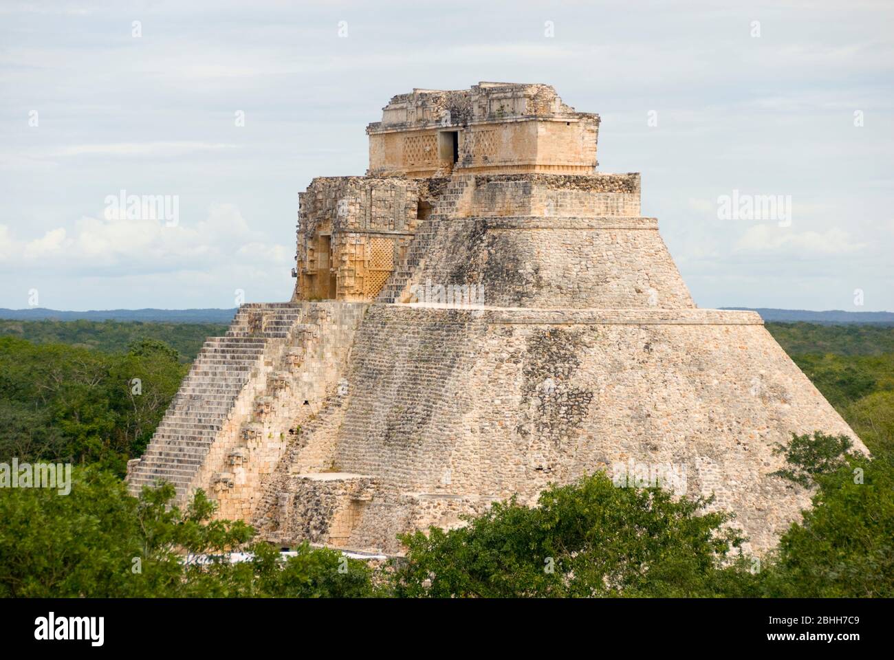 Mexico – Jan 19 2007: Adivino or The Pyramid of the Magician stands tall, looming  over the jungle canopy at  Uxmal Stock Photo