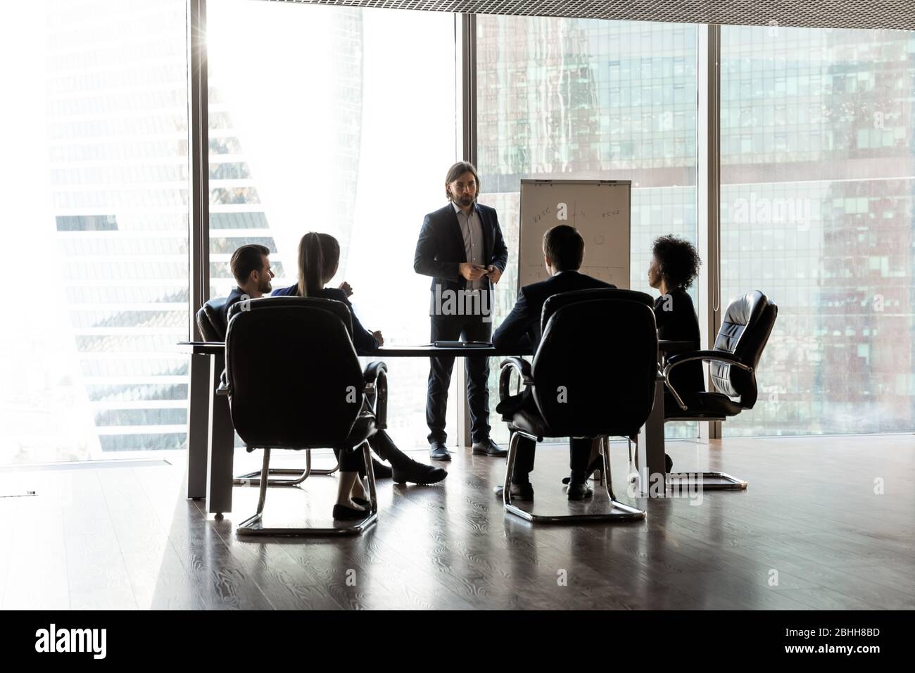 Confident team leader giving flip chart presentation at corporate meeting Stock Photo