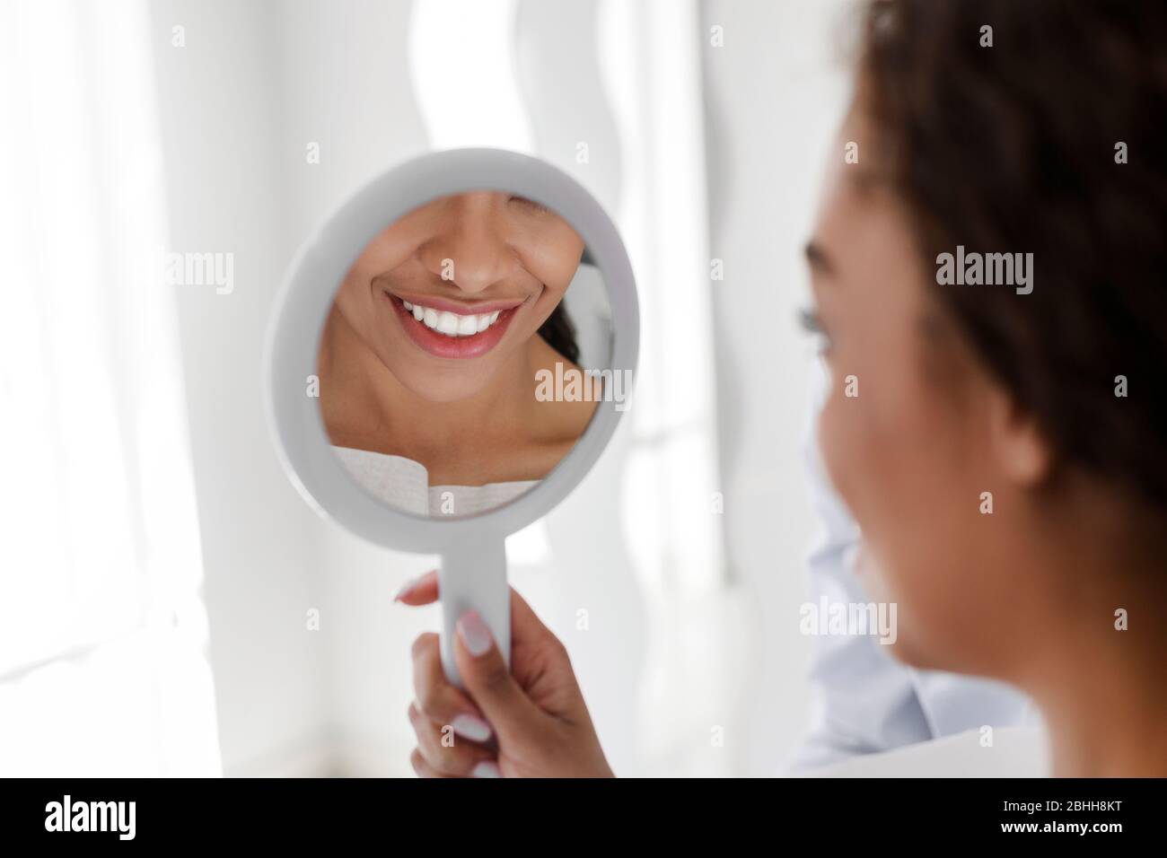 White smile in mirror, african girl visiting dentist Stock Photo