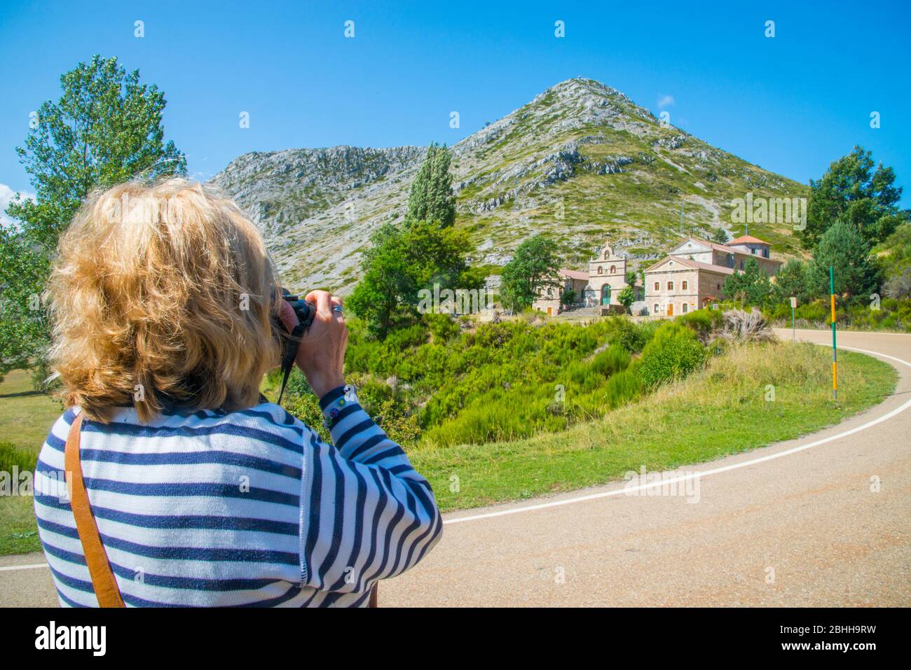 Mature woman taking photos of El Brezo sanctuary. Villafria de la Peña, Palencia province, Castilla Leon, Spain. Stock Photo