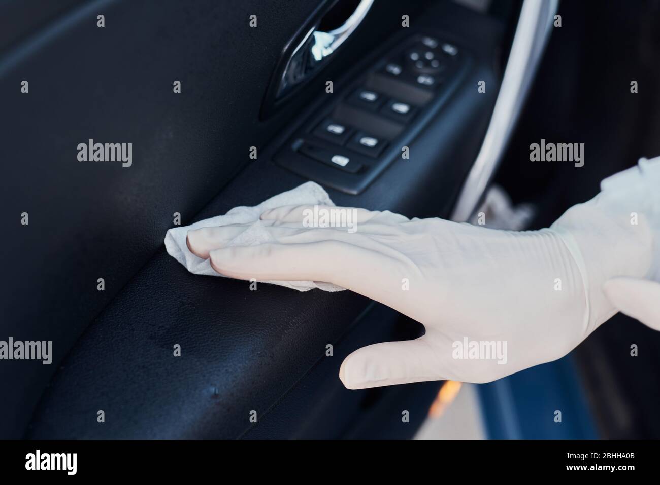 Woman cleaning car interior. Hand with antibacterial wipe disinfect car