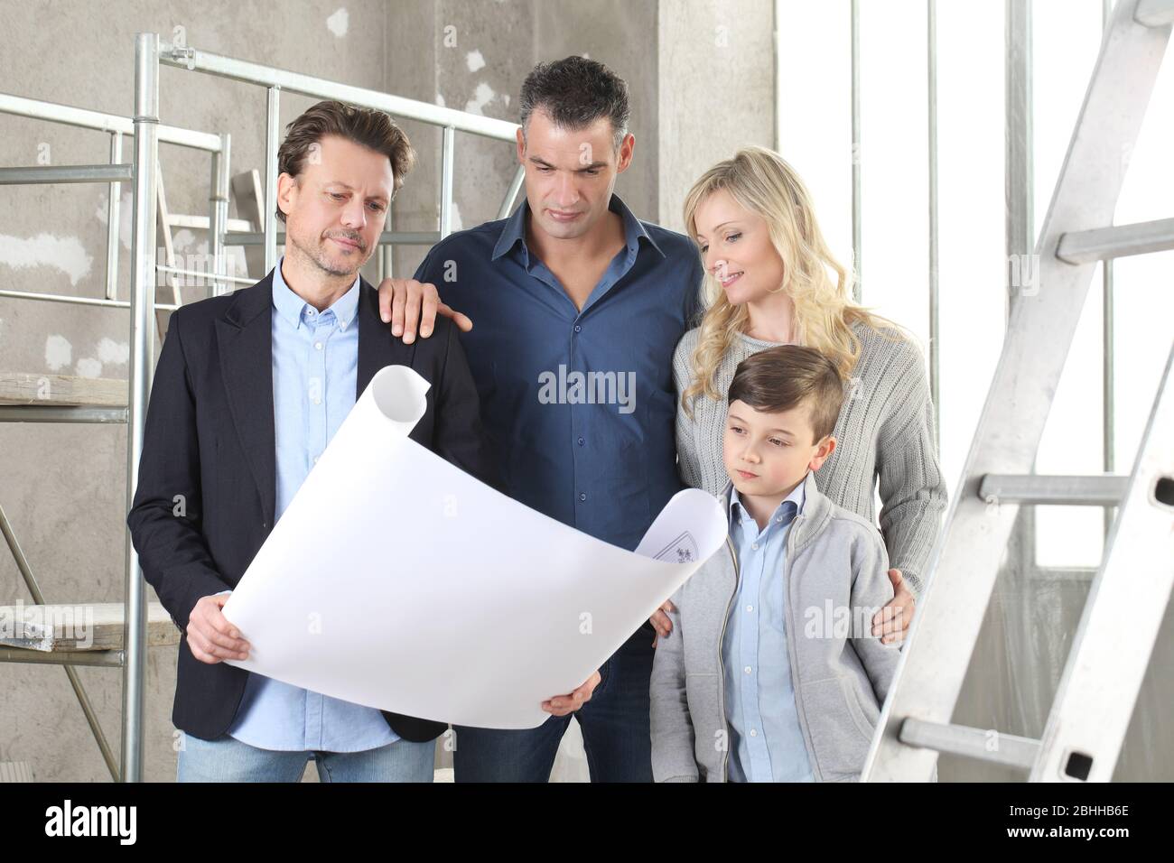 Architect showing house design plans to a family with child. Meeting at ...