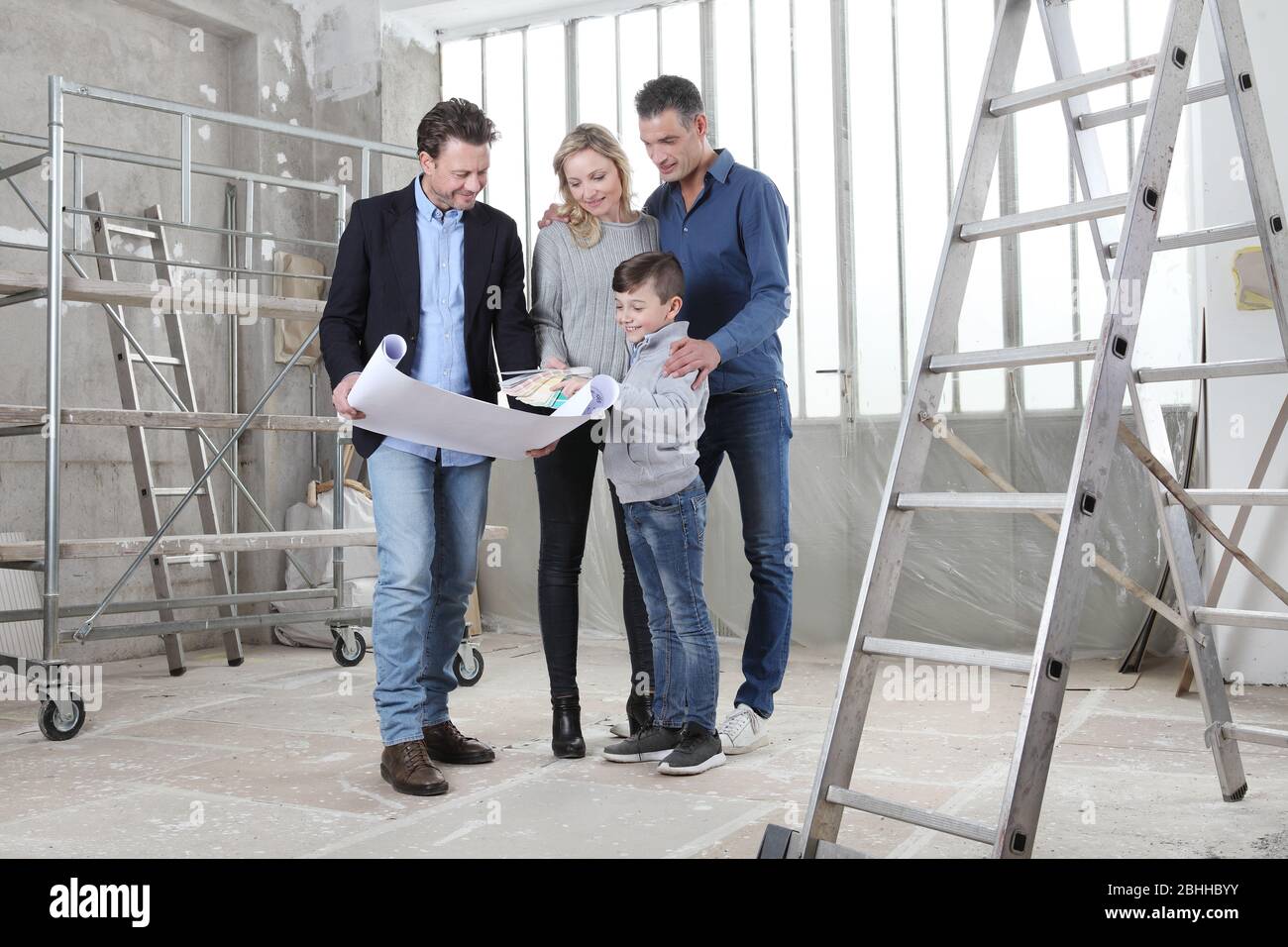 Architect showing house design plans to a family with child. Meeting at ...