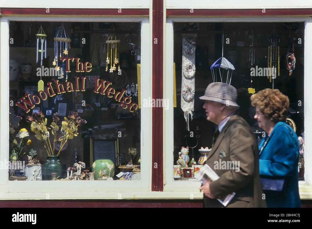 An elderly couple walking passed an antiques shop, Woodhall Spa, Lincolnshire, England, UK Stock Photo