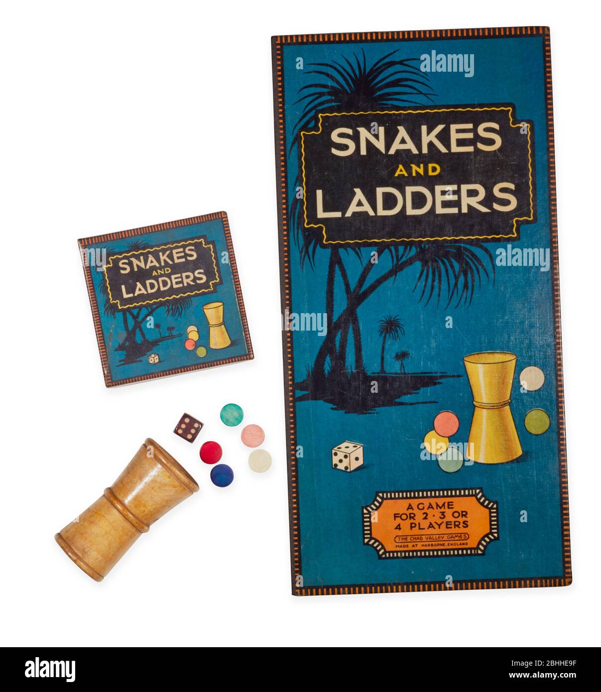 1930s games of Snakes and Ladders showing front of board, die, counters Stock Photo