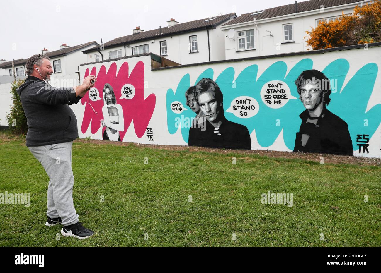 Pat O'Sullivan, chair of NINA For Life Suicide awareness group, takes pictures of Irish artist Emmalene Blake's new mural of The Police in South Dublin. This is the latest in the 'Stay At Home' series by the Dublin artist encouraging people to stick to social distancing. Other artists featured have been Dua Lipa, Robyn and Cardi B. Stock Photo