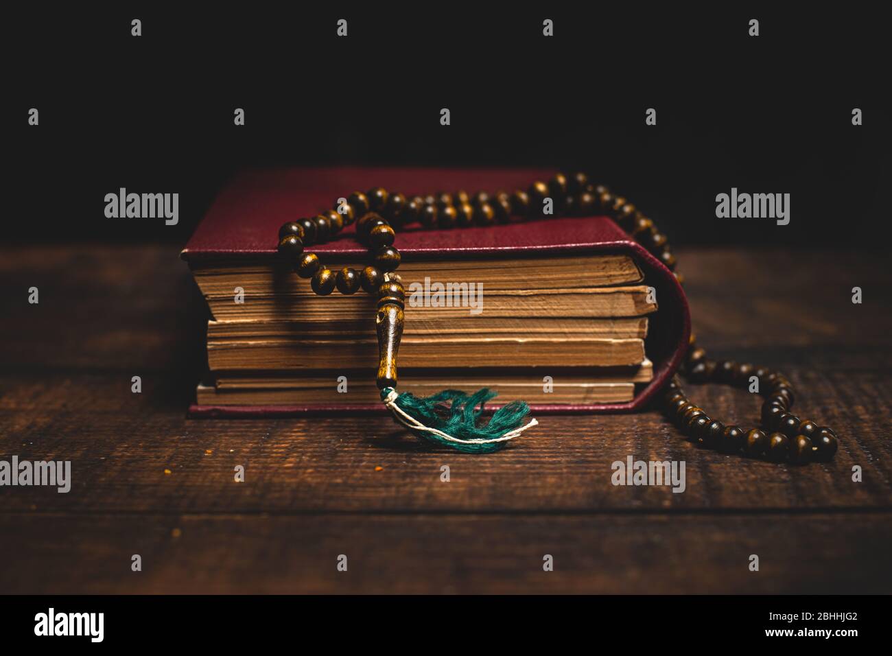 Holy Al Quran and prayer beads on wooden table. Ramadan muslim religion concept. Stock Photo