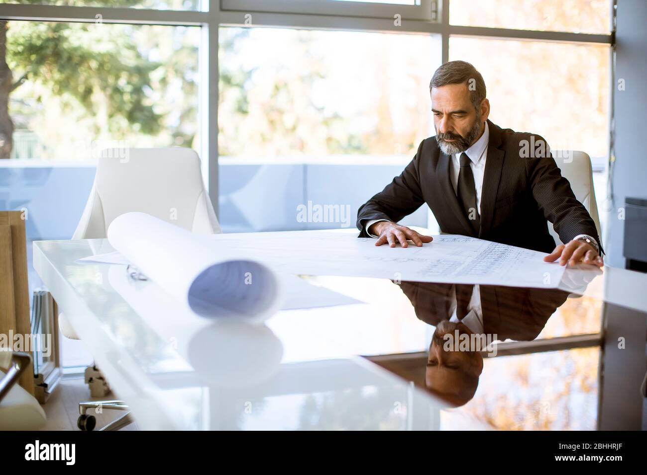 Handsome architect checking plans and blueprints in the office Stock Photo