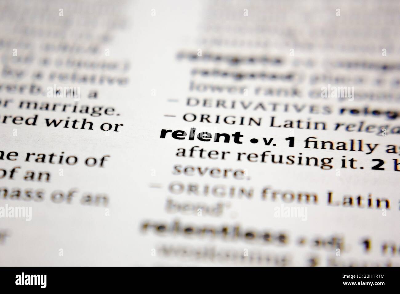 Word or phrase relent in a dictionary. Stock Photo