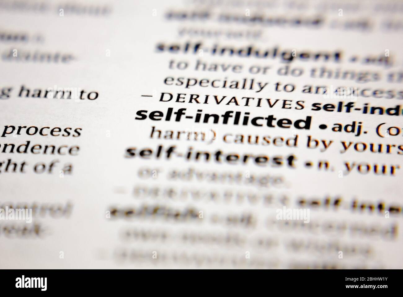 Word or phrase self-inflicted in a dictionary. Stock Photo