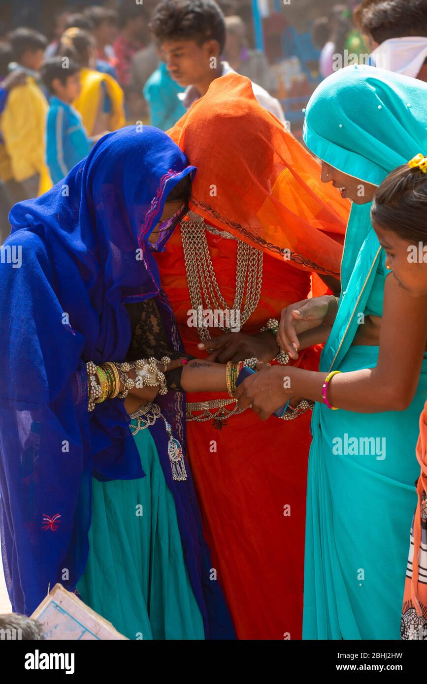 Alirajpur / India 9 March 2020 Indian tribal bhil women in traditional indian dress looking at his tattoo on hand during Bhagoria fair in Alirajpur di Stock Photo