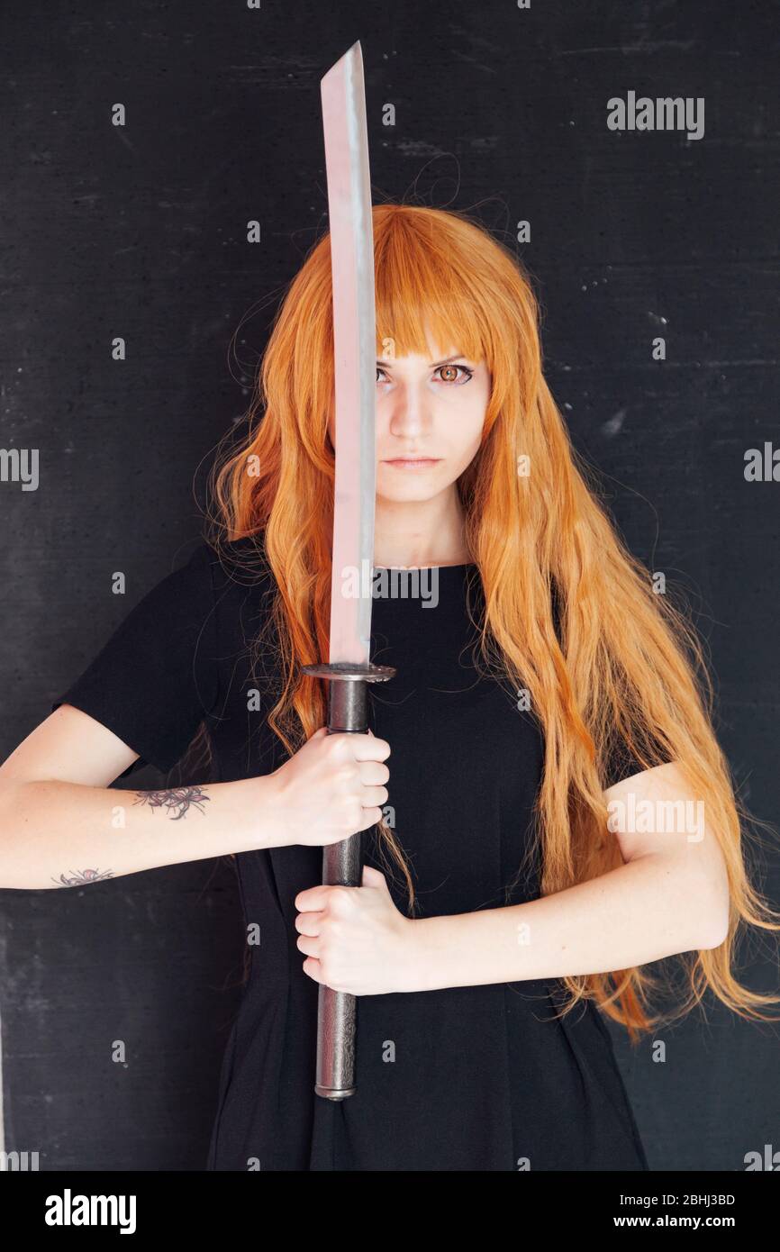 woman anime cosplayer with red hair Japanese sword Stock Photo - Alamy