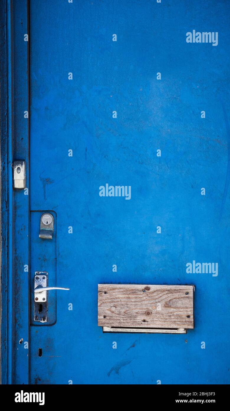 Blue door with boarded up letterbox Stock Photo