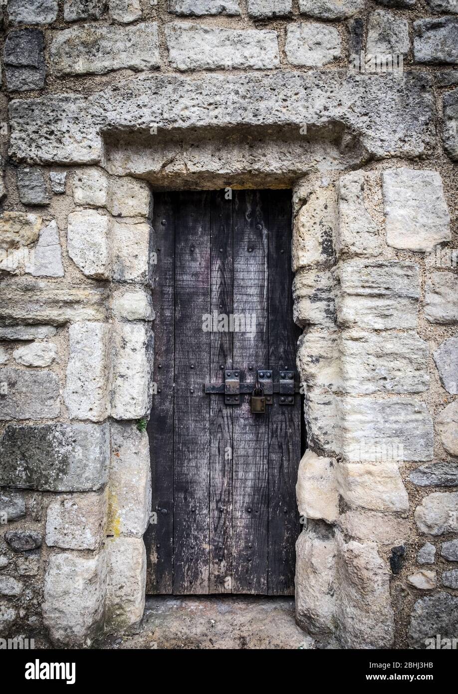Old wooden door in a medieval wall Stock Photo