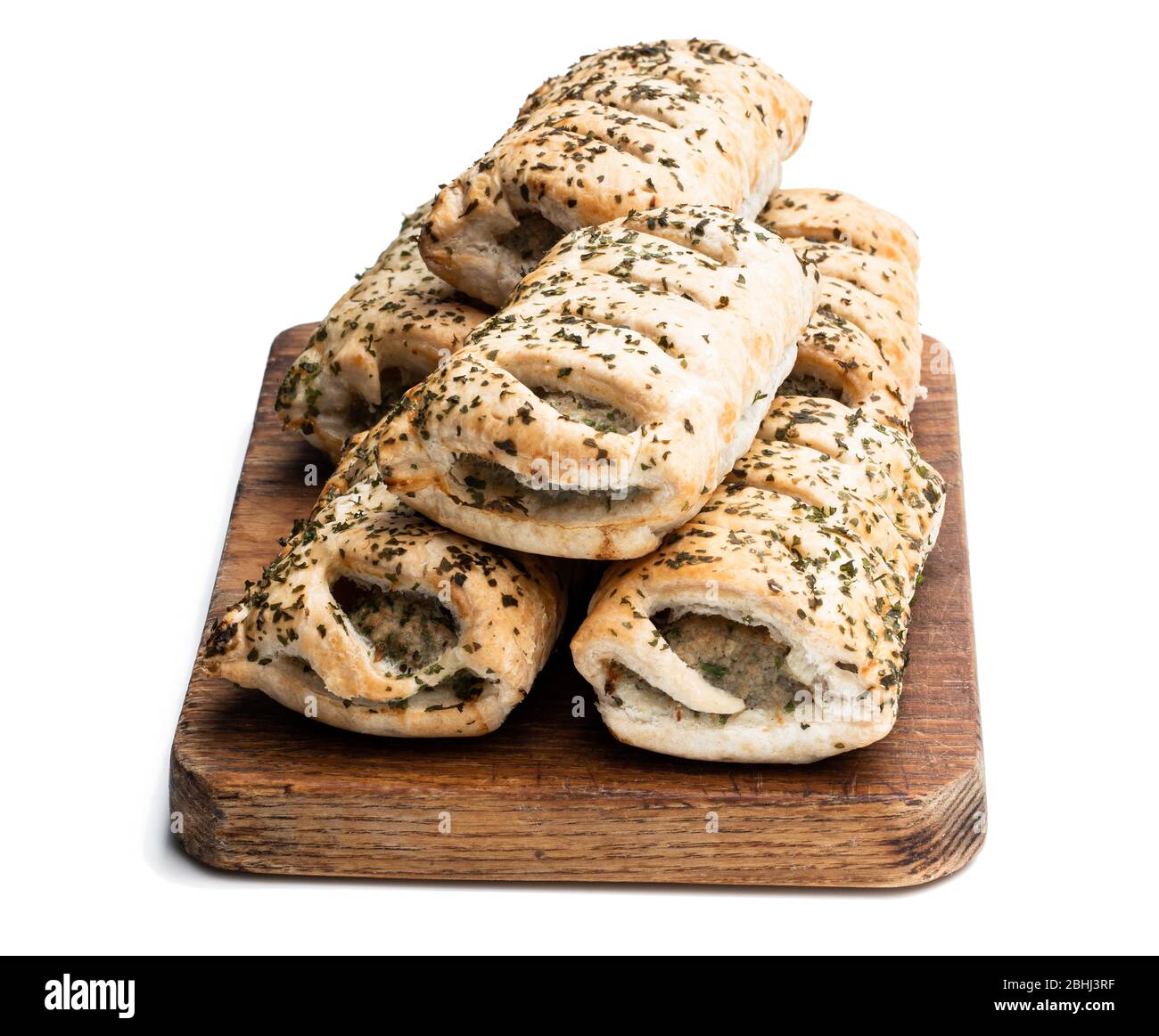 Sausage meat in puff pastry topped with herbs isolated on white Stock