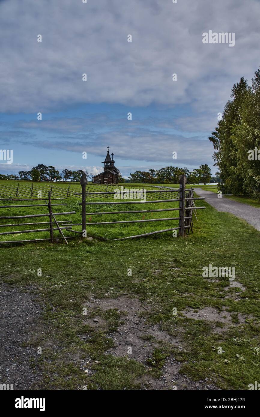The field is fenced by sloping poles. A typical rural fence around ...