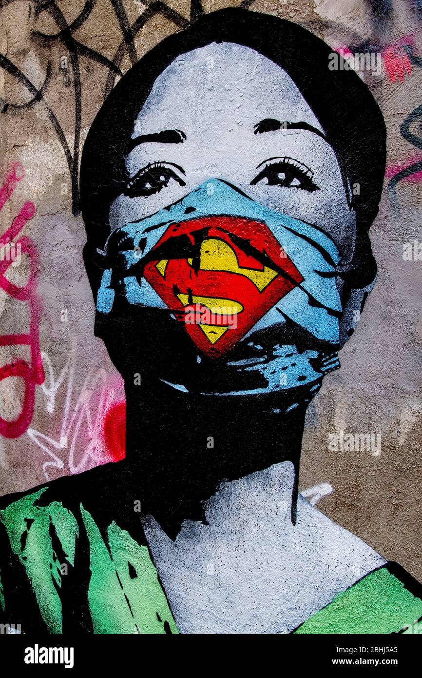 Illustration of a graffiti of a super nurse  by Fake an artist on a wall of the former NDSM shipyard in the north of Amsterdam symbolizing the current worldwide Coronavirus crisis. A graffiti's an illustration of a nurse wearing a mask with the Superman logo symbolizing the fight against the Covid-19 in tribute of the doctors and nurses around the world. Stock Photo