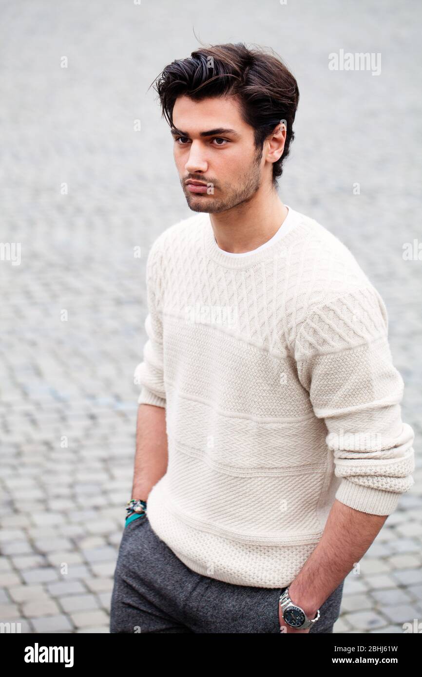 Handsome young man outdoor in the street with hands in the pockets. Fashion hairstyle, confident attitude. White sweater. Stubble Stock Photo - Alamy Handsome young man outdoor in the street with hands in the pockets. Fashion hairstyle, confident attitude. White sweater. Stubble Stock Photo - Alamy