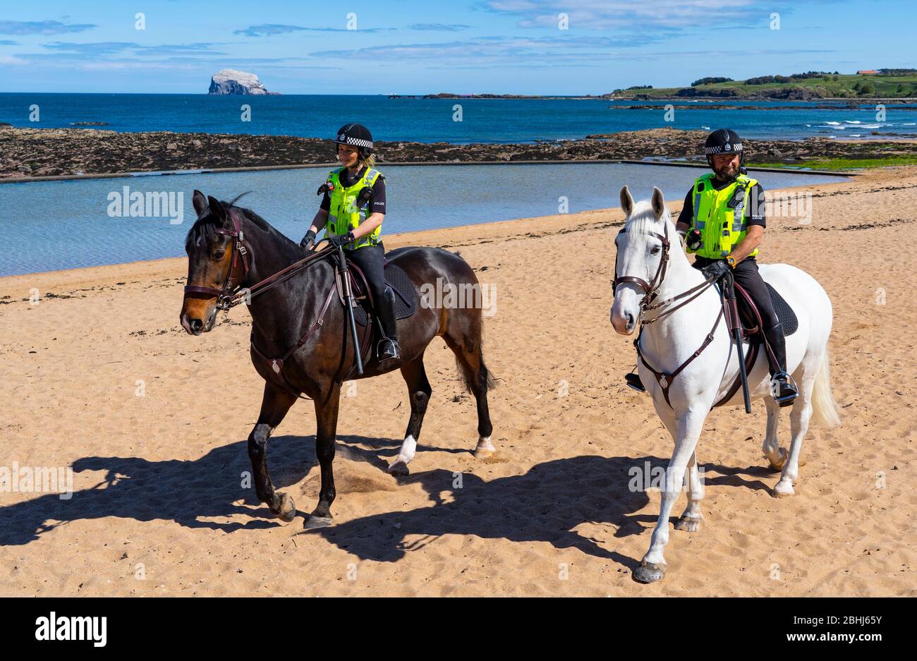 North Berwick, Scotland, UK. 26 April 2020. Mounted police patrolling the beaches of North Berwick in East Lothian this afternoon. Horses Inverness (dark) and Edinburgh travelled from their stables in Stewarton in Ayrshire for today’s walk. However the beaches were very quiet and the horses’ main duty was to pose for photographs with the few people outdoors.  Iain Masterton/Alamy Live News Stock Photo
