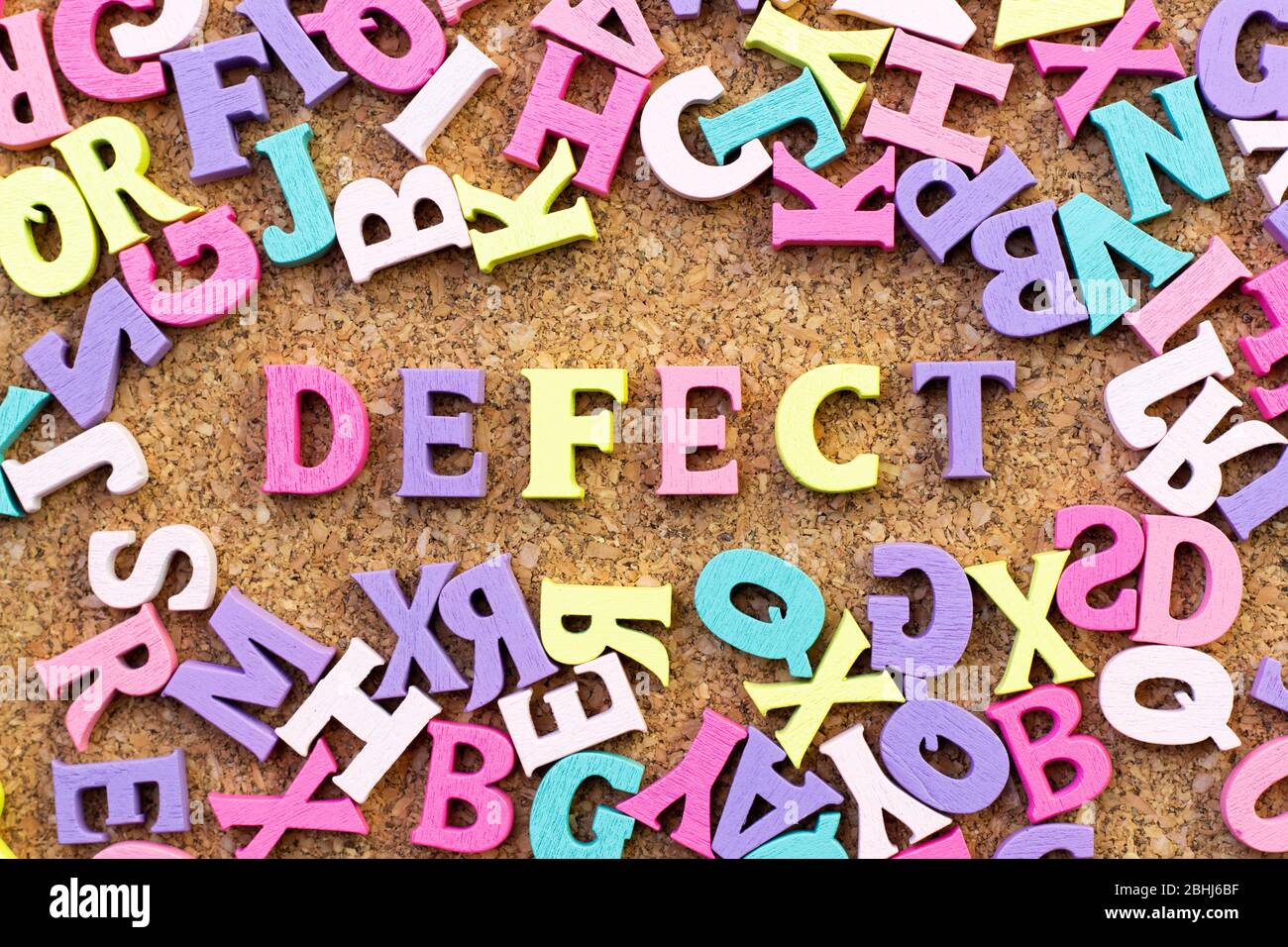Color alphabet in word defect with another letter as frame on cork