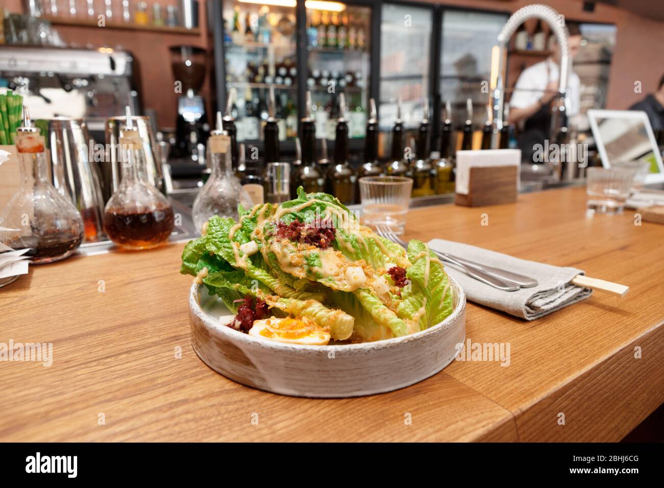 Caesar salad cooked in Asian way served on bar counter Stock Photo Alamy