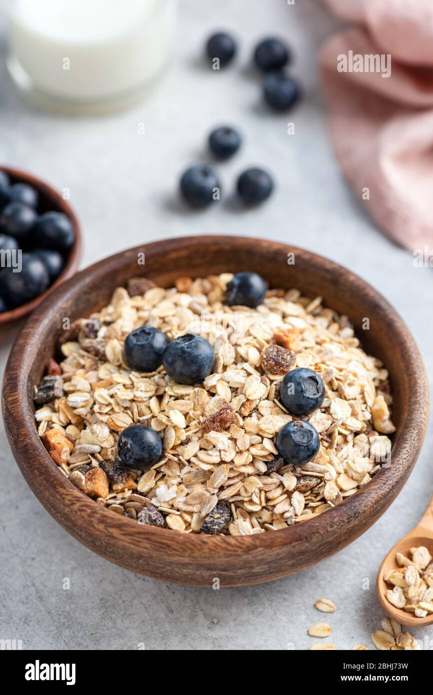 Bowl of oat muesli with nuts, dried fruit and blueberries. Healthy breakfast food, clean eating and dieting concept. Breakfast cereals Stock Photo