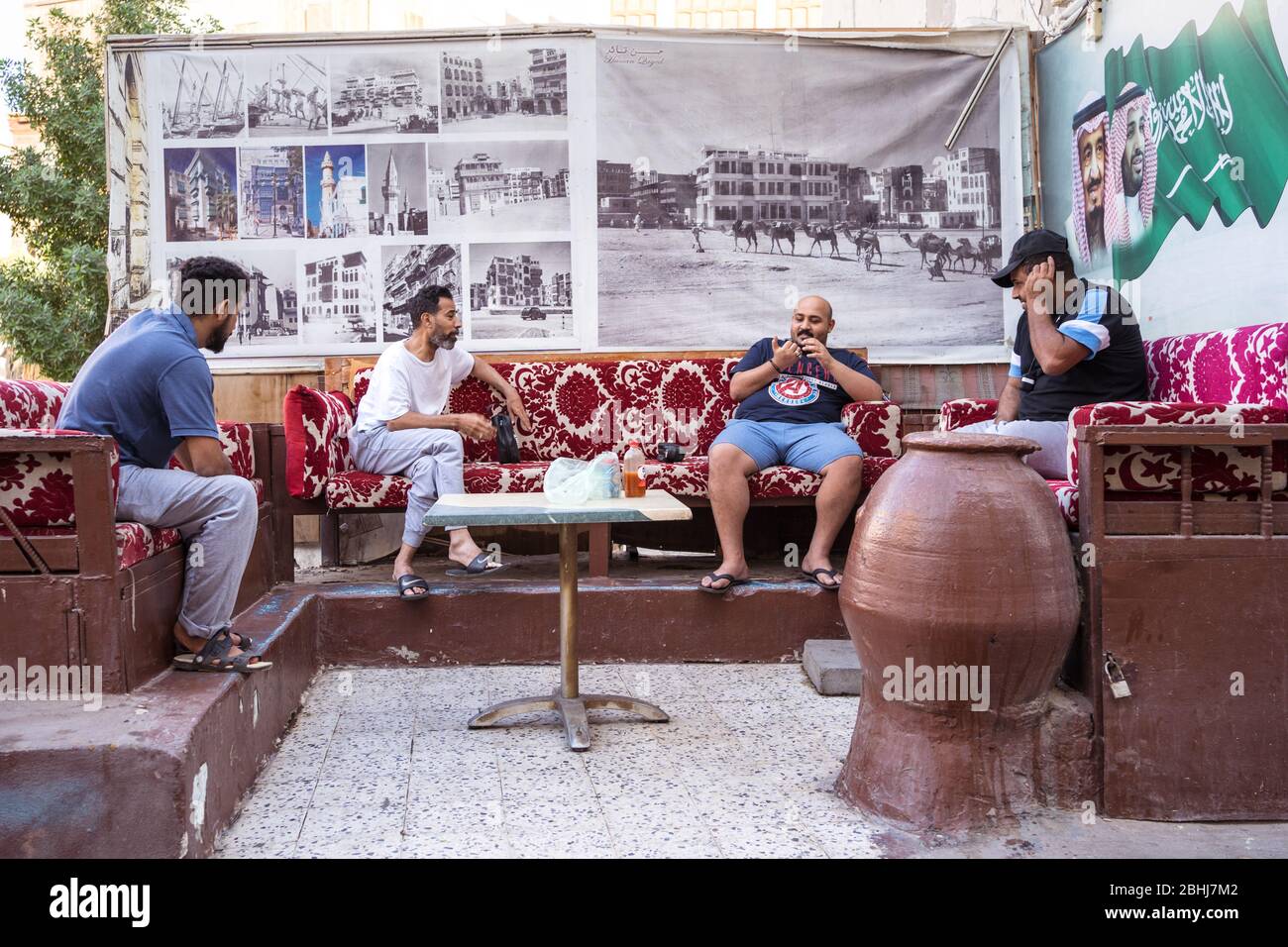 Jeddah / Saudi Arabia - January 16, 2020: young men talking sitting in couches on the streets of central Jeddah Stock Photo