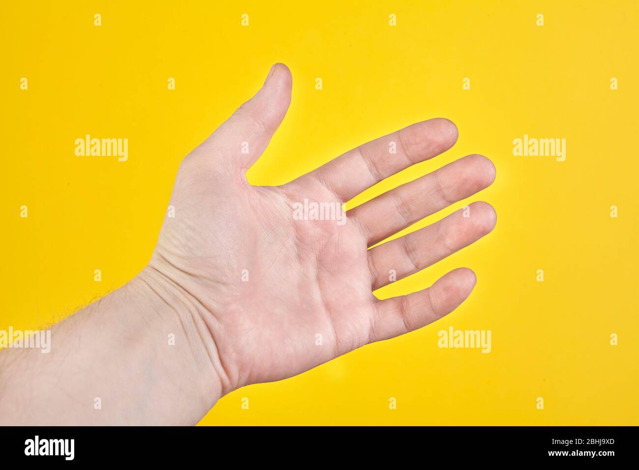 Open palm isolated on yellow background. Close up Stock Photo
