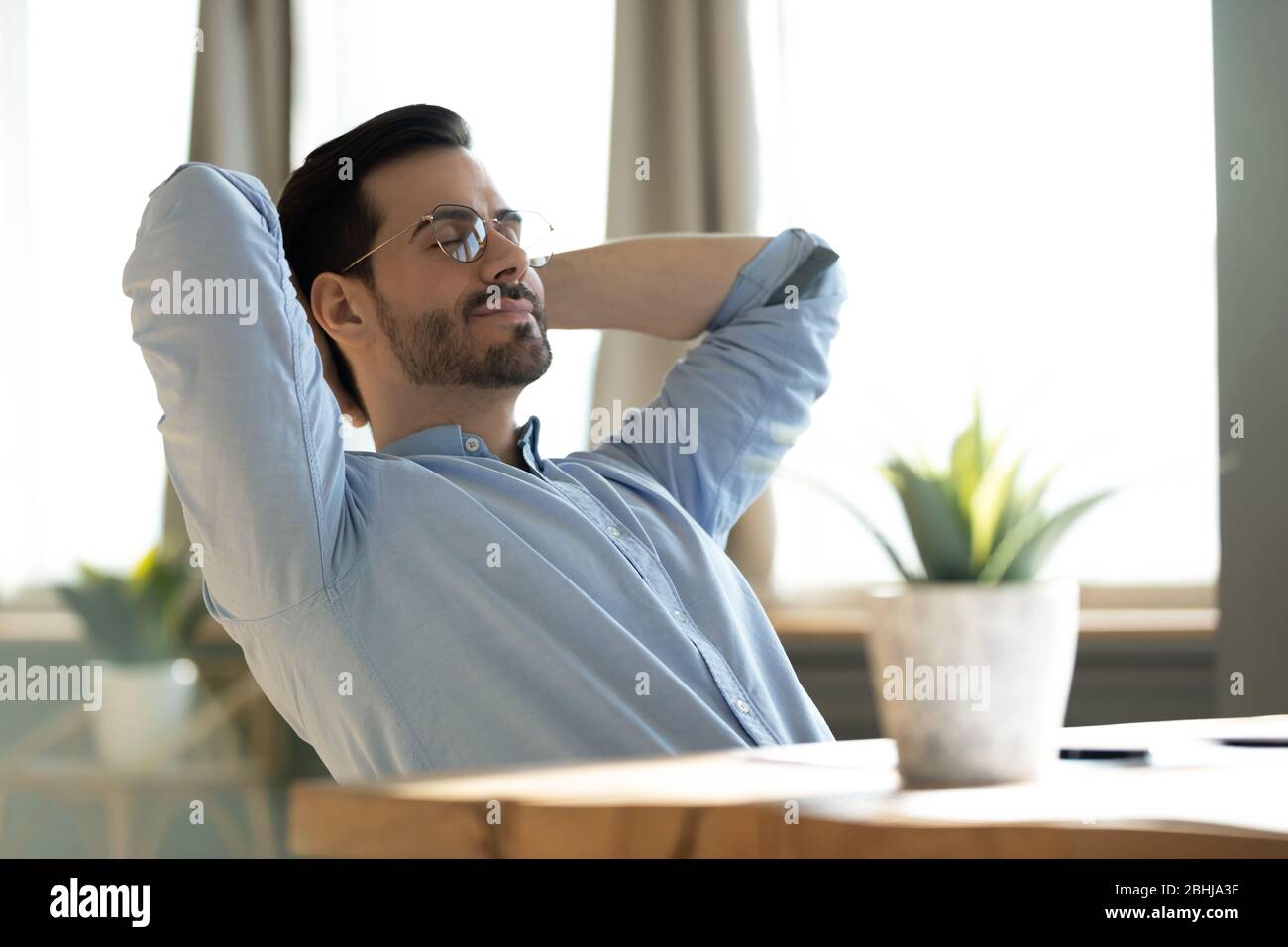 Satisfied young man sitting hi-res stock photography and images - Alamy
