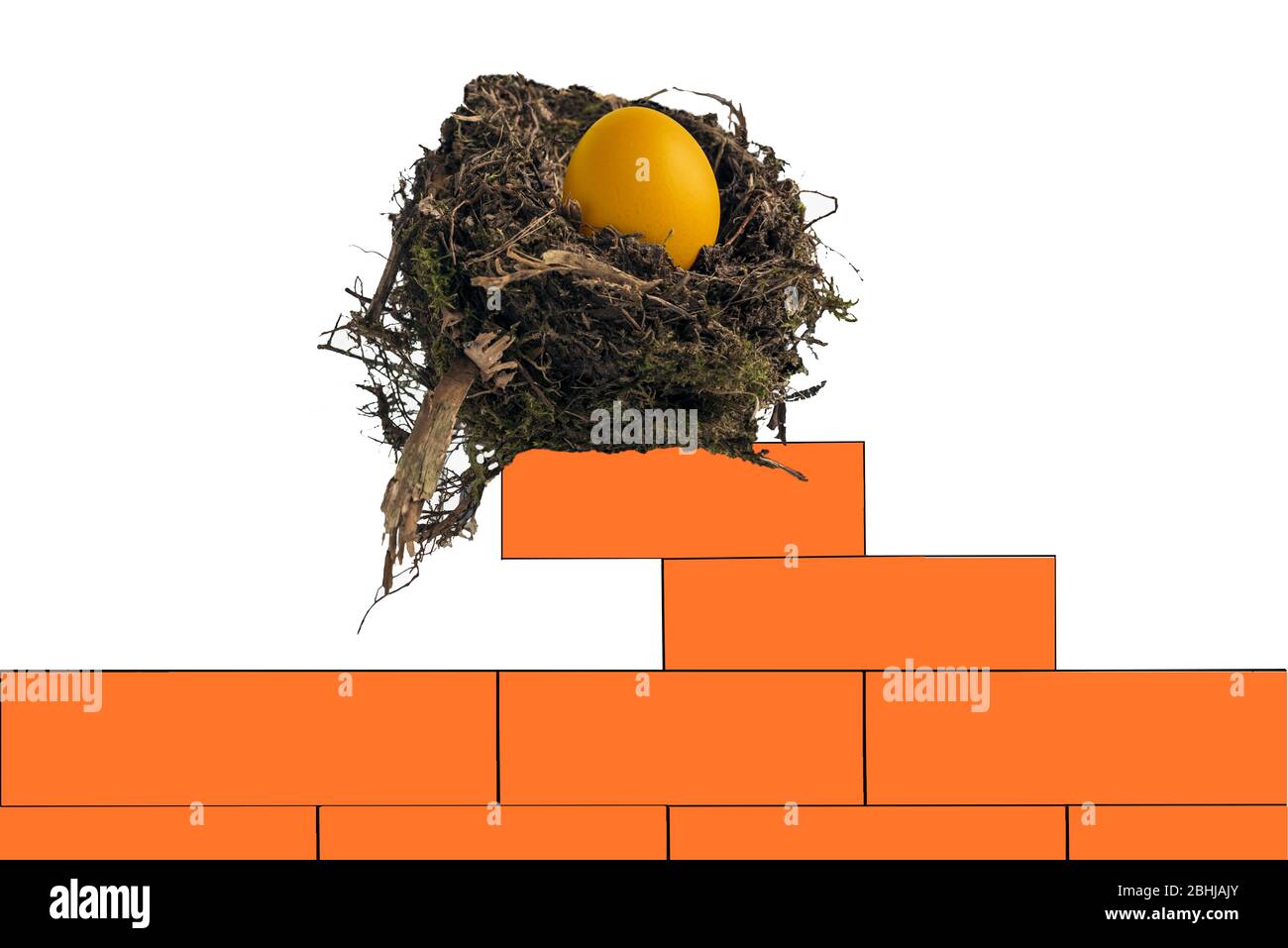 Bird's nest containing a golden egg sitting precariously on a wall of red bricks. Concept: building a nest egg, solid investment, asset value, risk Stock Photo