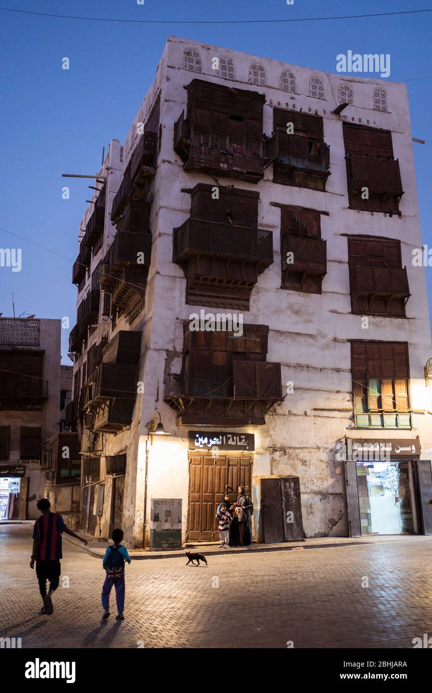 Jeddah / Saudi Arabia - January 16, 2020: Night view of street of old town historic Al-Balad with people walking and wooden balconies in buildings Stock Photo