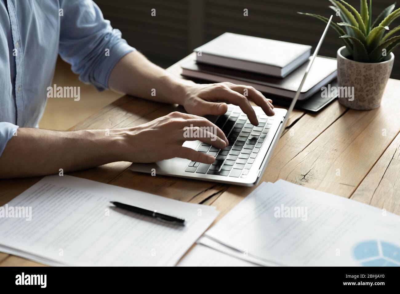 Close up businessman using laptop, sitting at work desk Stock Photo