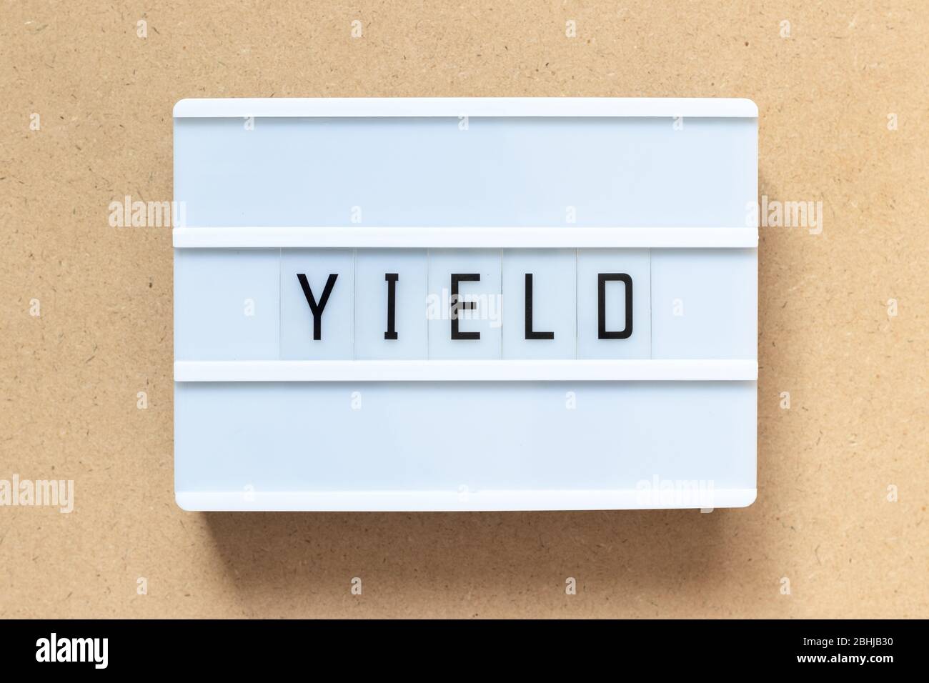 White lightbox with word yield on wood background Stock Photo