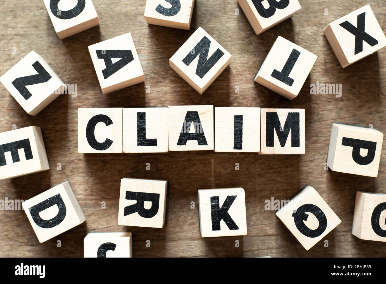 Wood letter block in word claim on wood background with another ...