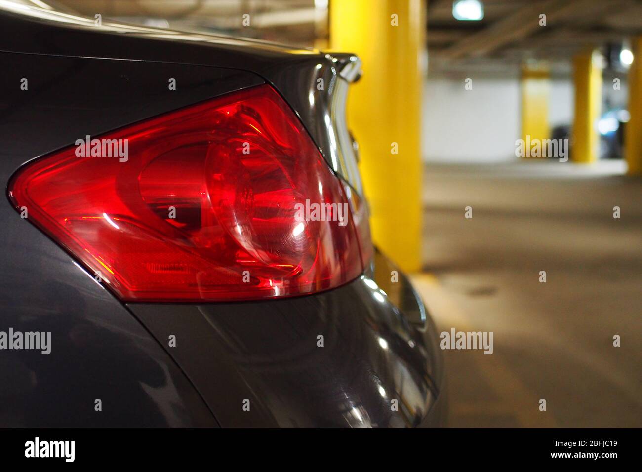 Close up of the red left rear tail brake / indicator light of a parked