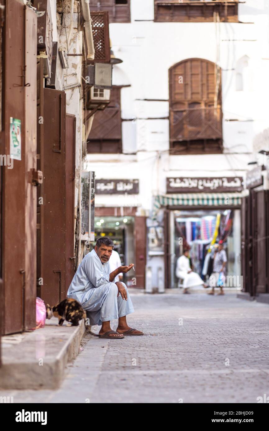 Jeddah / Saudi Arabia - January 16, 2020: Portrait of Muslim men sitting in front of historic building facade in Al-Balad Stock Photo