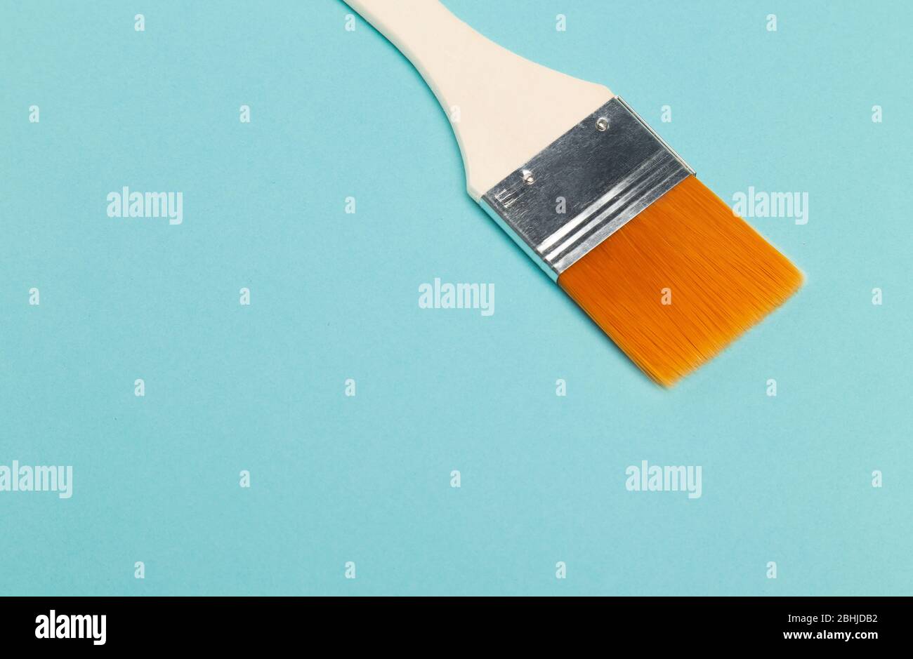 Paint brush isolated on blue background with copyspace. Stock Photo
