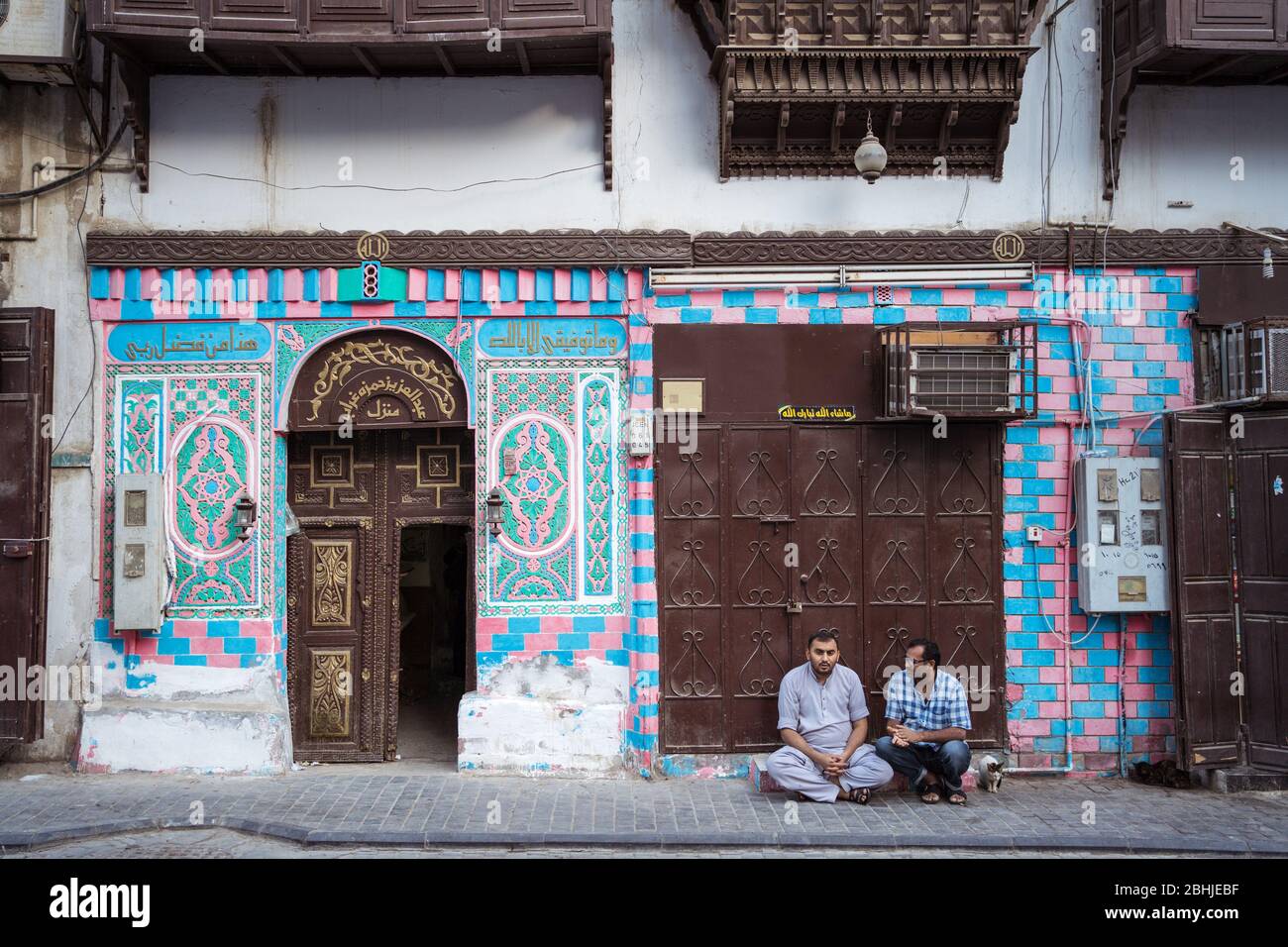 Jeddah / Saudi Arabia - January 16, 2020: Portrait of Muslim men sitting in front of historic building facade in Al-Balad Stock Photo