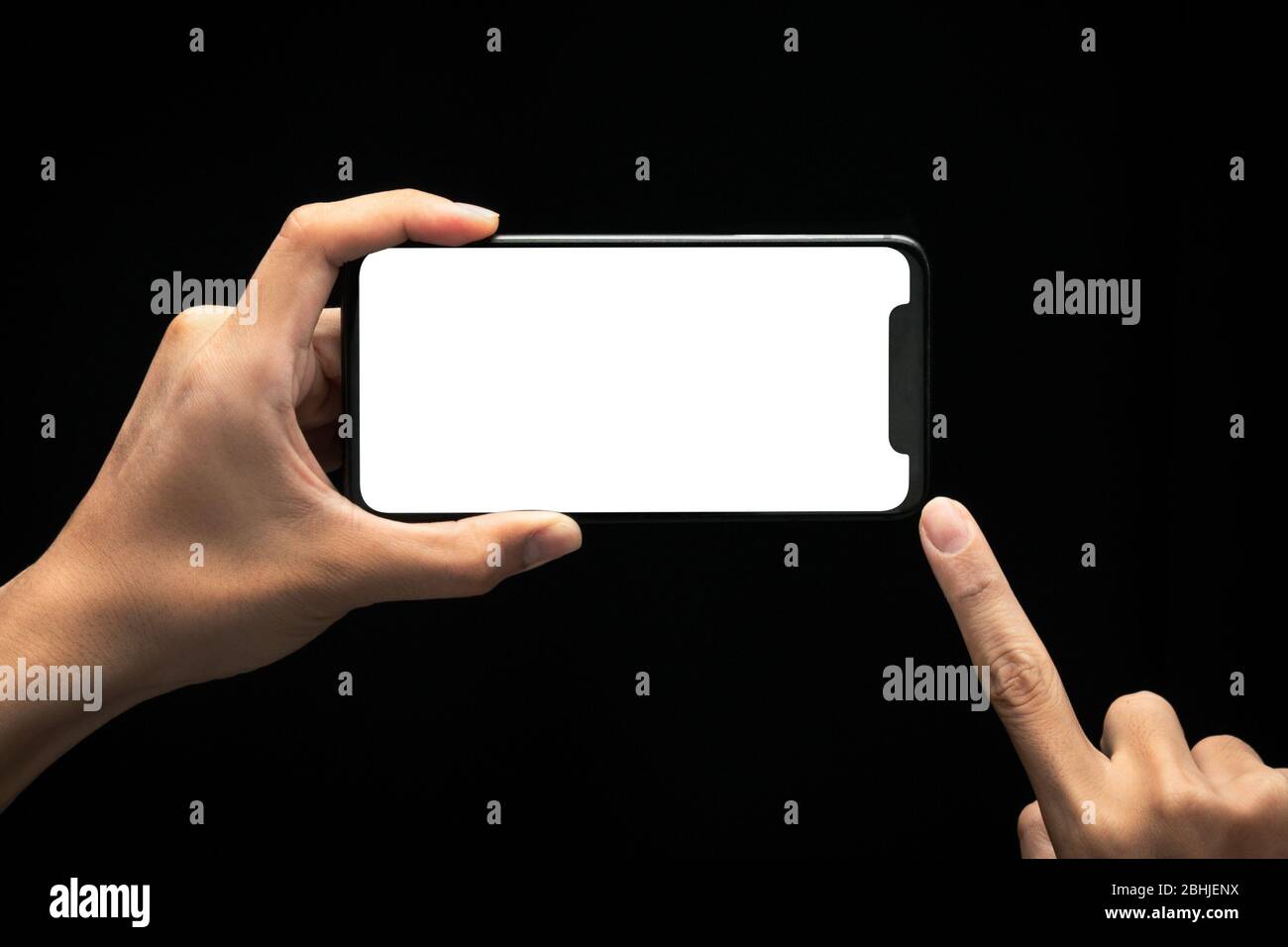 Male hands holding and using smartphone with blank screen at night ...