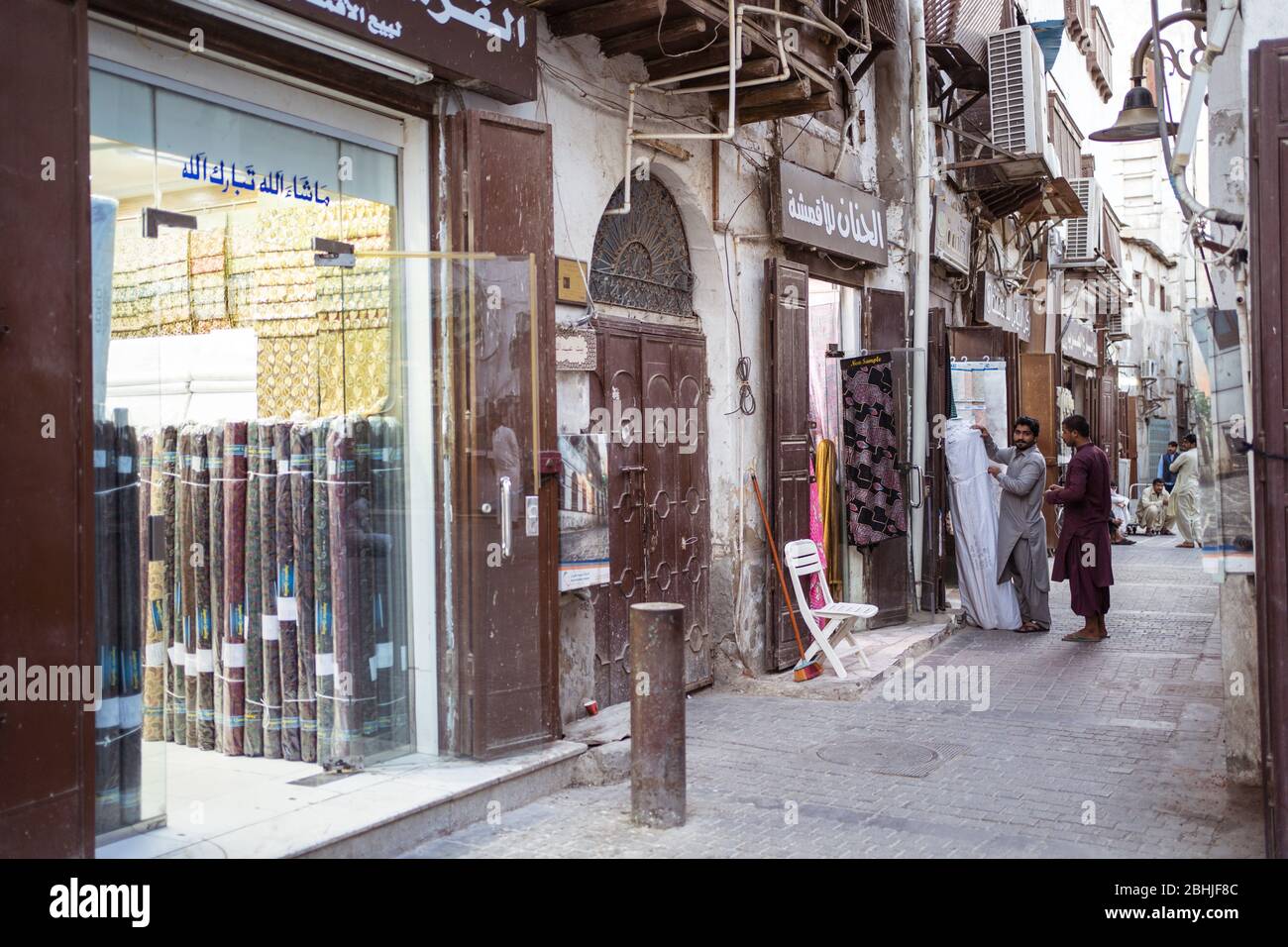 Jeddah / Saudi Arabia - January 16, 2020: Immigrant workers in street with shops in Jeddah old town Stock Photo