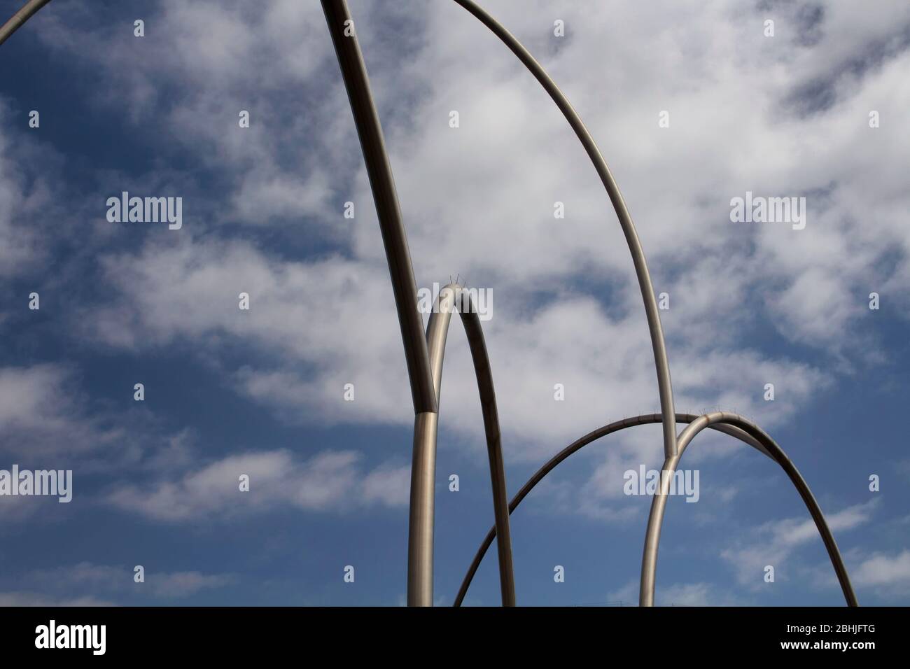 View of gigantic, modern sculpture with cloudy blue sky background in Barcelona port. It is named Waves (Onades) by Andreu Alfaro. It is a sunny summe Stock Photo