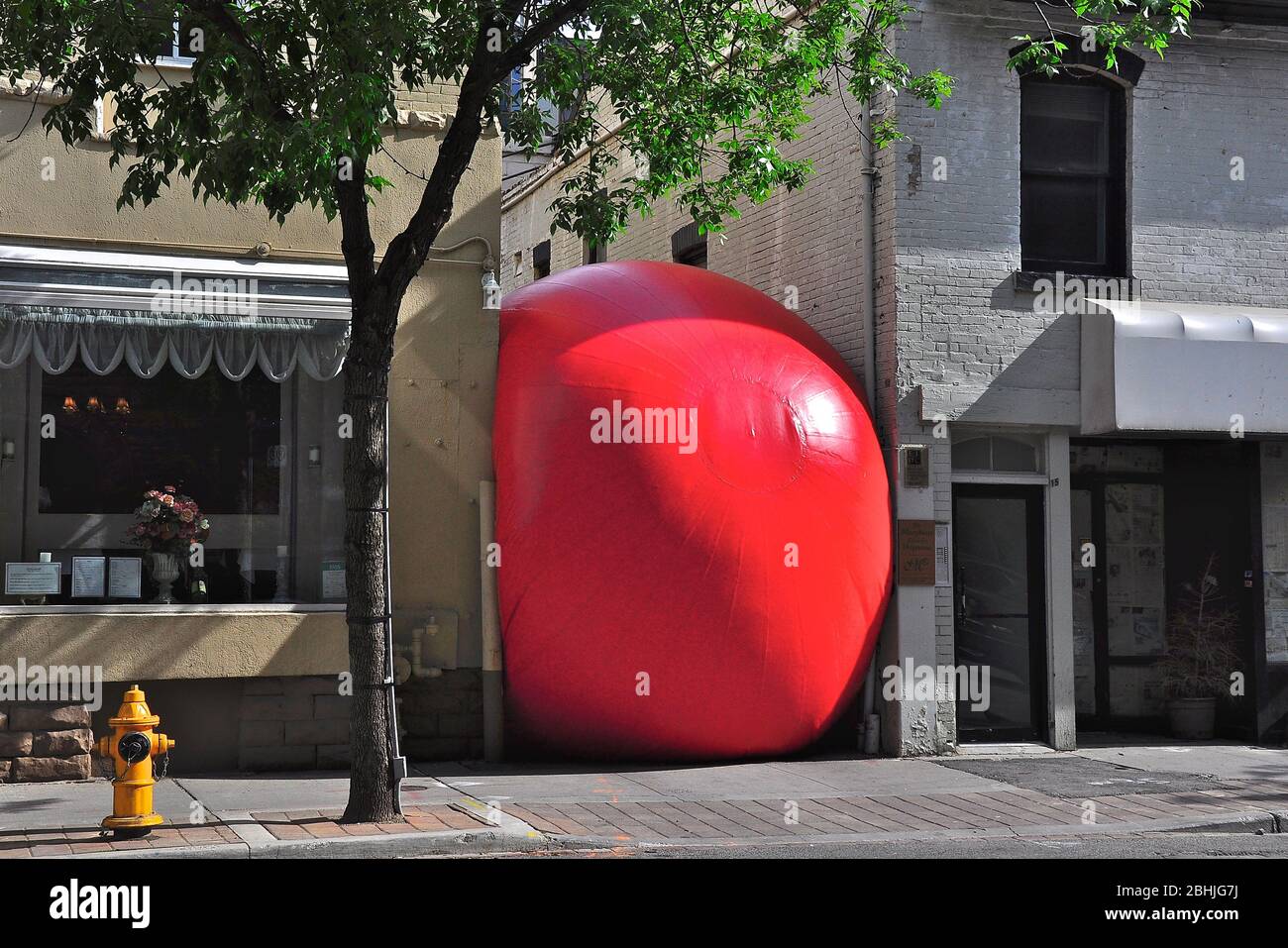 Toronto, Ontario, Canada - 06/12/2009:  A huge red ball is installed as public art exhibitions between buildings in Toronto downtown. Stock Photo