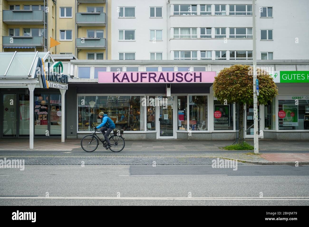 Kiel, Germany. 26th Apr, 2020. A cyclist passes a shop ('Kaufrausch') in the Holtenauer Straße in the city centre of Kiel on a Sunday when the shop is open for business. Credit: Gregor Fischer/dpa/Alamy Live News Stock Photo
