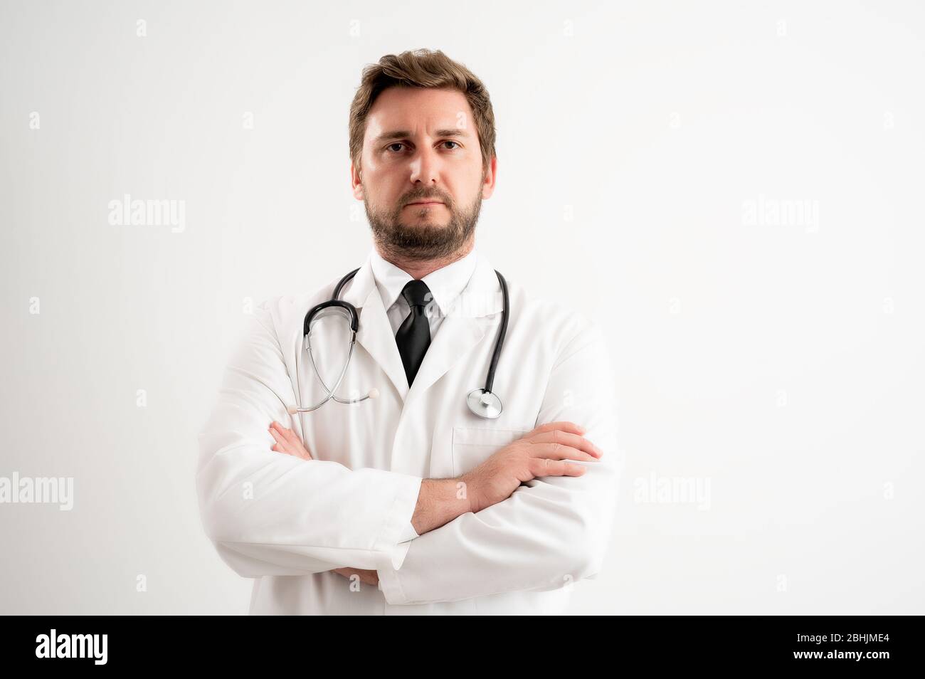 Portrait of male doctor with stethoscope in medical uniform looking confident posing on a white isolated background. Stock Photo