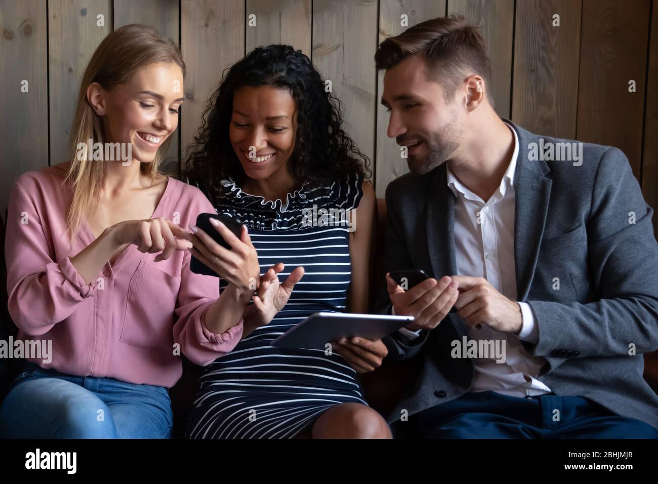 Multiracial couple relax on couch using gadgets Stock Photo