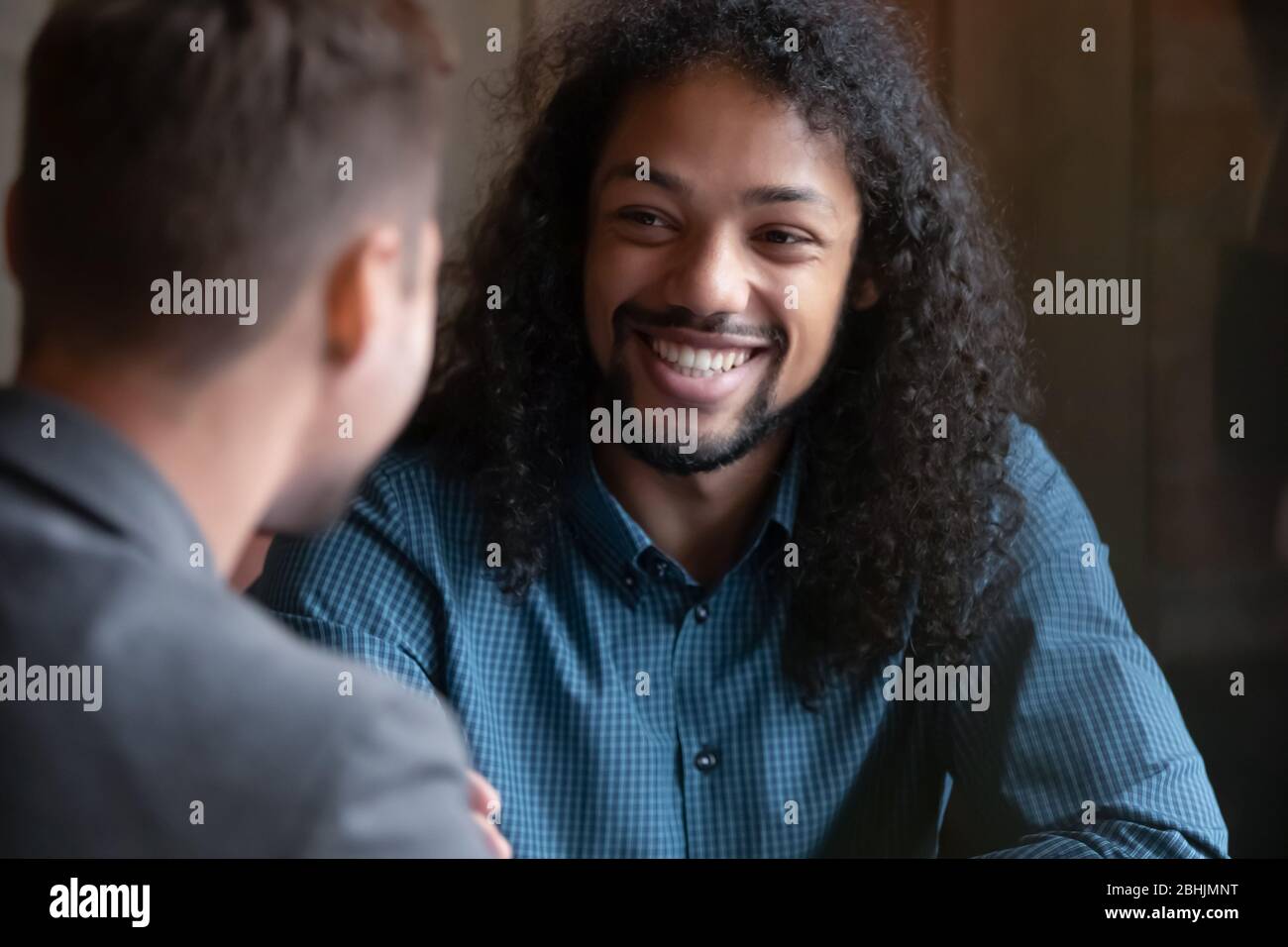 Smiling biracial guy have fun meeting with male friend Stock Photo